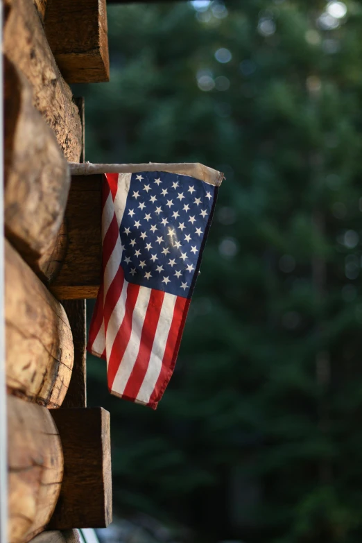 an american flag hanging from the side of a log cabin, unsplash, slide show, multiple stories, closeup 4k, album