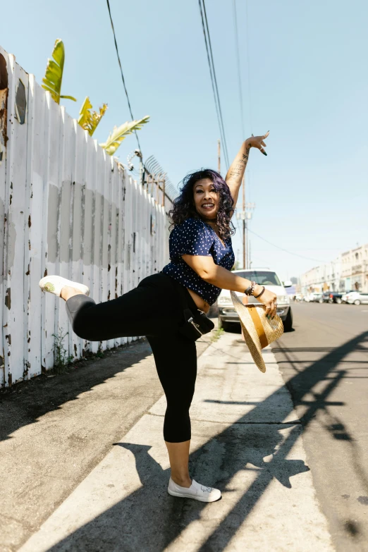 a woman standing on the side of a road holding a banana, by Carey Morris, happening, dynamic dancing pose, neighborhood, alanis guillen, justina blakeney