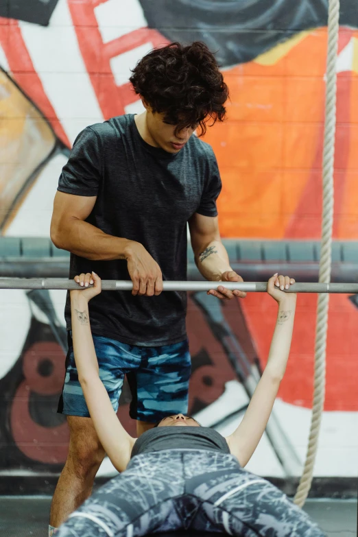 a man and a woman doing push ups in a gym, by John Luke, holding a staff, tony taka, profile image, hanging