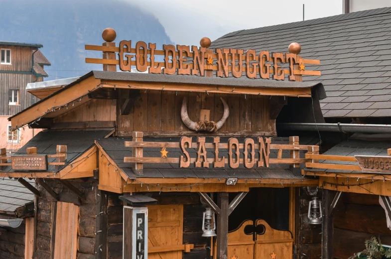 a wooden building with a sign on top of it, a photo, western saloon theme, golden colour, profile image, decoration