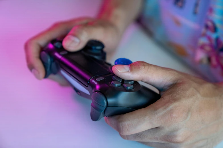a close up of a person holding a video game controller, pexels, blue and pink lighting, avatar image, playstation 4, instagram post