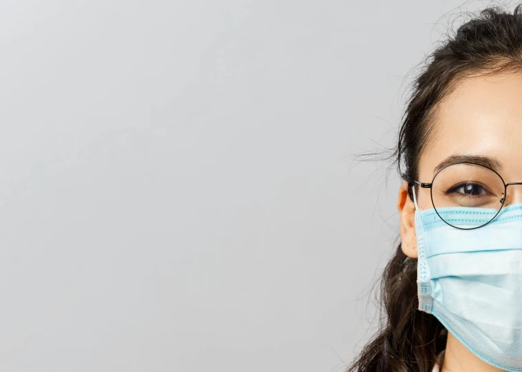 a woman wearing a face mask and glasses, a picture, shutterstock, mingei, on grey background, long chin, asian descent, local conspirologist