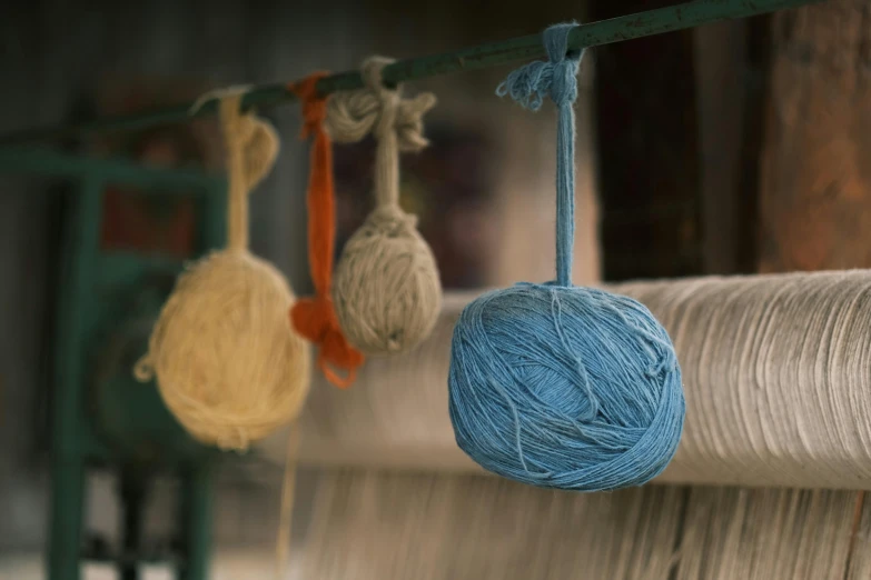 a close up of yarn on a loom, a portrait, inspired by Toss Woollaston, unsplash, cerulean, beautiful surroundings, india, in a row