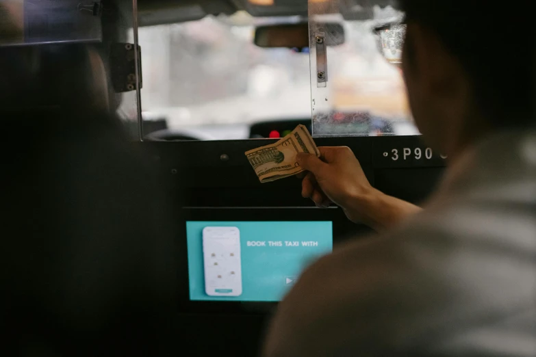 a person standing in front of a cash machine, by Benjamin Block, trending on unsplash, hurufiyya, taxi, with people inside piloting it, square, close up to the screen