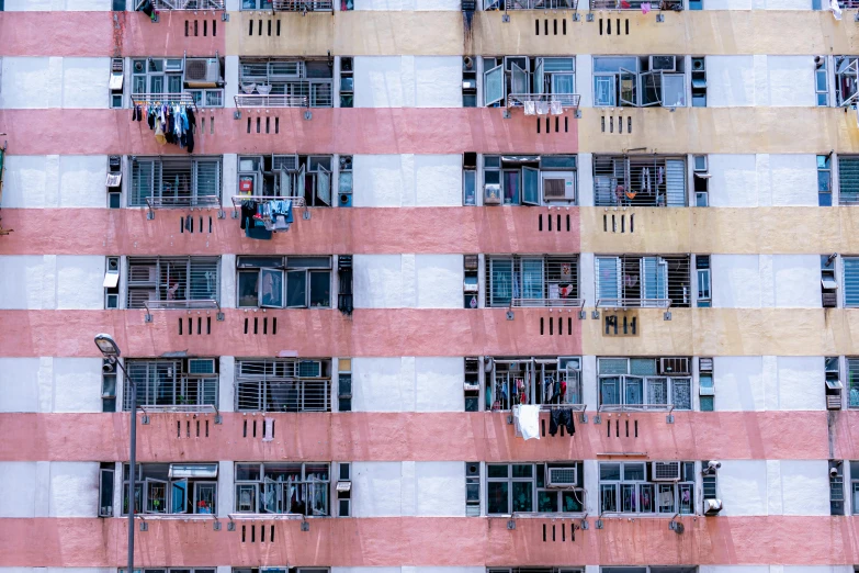 a tall building filled with lots of windows, inspired by Zhang Kechun, unsplash contest winner, hyperrealism, colorful patterns, half - occupied with people, kowloon walled city style, pastel colors only
