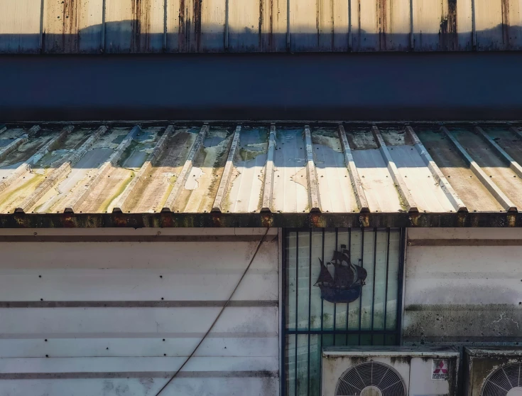 a couple of air conditioning units on the side of a building, an album cover, unsplash, galvalume metal roofing, aged and weathered, shop front, contrast of light and shadows