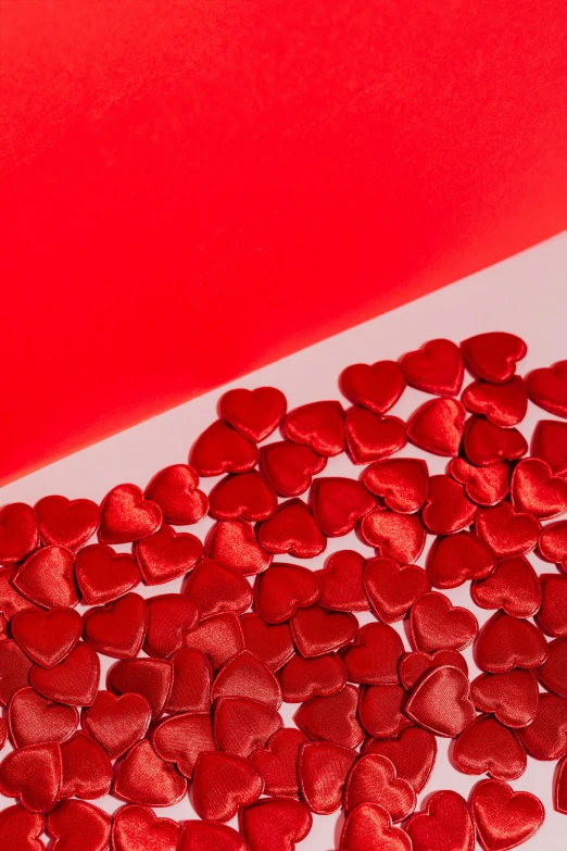 a table topped with lots of red hearts, product shot, foil, zoomed in, satin