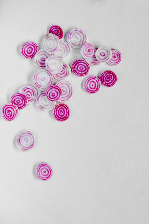 a pair of scissors sitting on top of a cutting board, pink jellyfish everywhere, concentric circles, made of lollypops, with a white background
