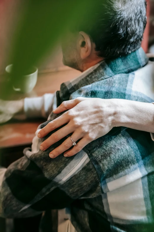 a man and woman hugging each other at a table, trending on pexels, sitting on man's fingertip, showing her shoulder from back, nursing home, soft details