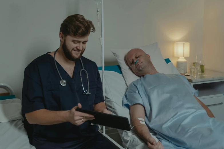 a man laying in a hospital bed next to a man with a stethoscope, a colorized photo, pexels contest winner, sad prisoner holding ipad, background image, cinematic footage, no words 4 k