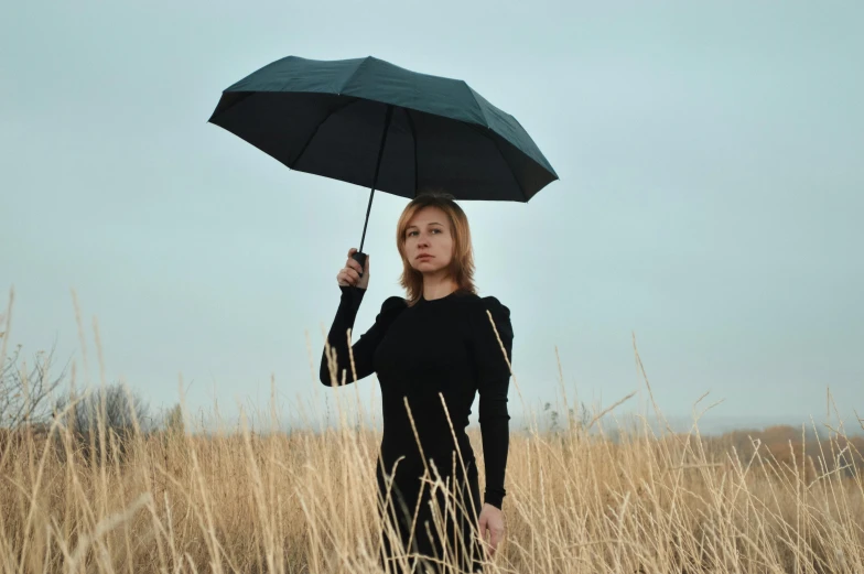 a woman standing in a field holding an umbrella, wearing black clothes, instagram picture, portrait image, sergey krasovskiy