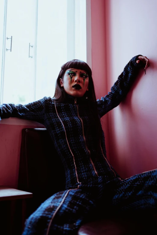 a woman sitting on a bench in front of a window, an album cover, unsplash, bauhaus, patterned clothing, she has black hair with bangs, in a menacing pose, on a checkered floor
