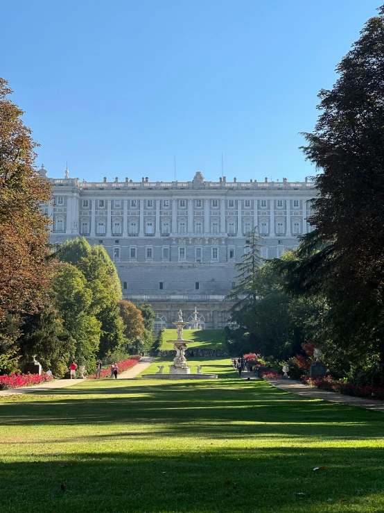 a large white building sitting on top of a lush green field, baroque, spanish princess, in the middle of the city, 🚿🗝📝