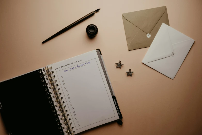 a notepad sitting on top of a desk next to a pen, by Julia Pishtar, trending on pexels, postminimalism, brown and pink color scheme, email, magic list, background image