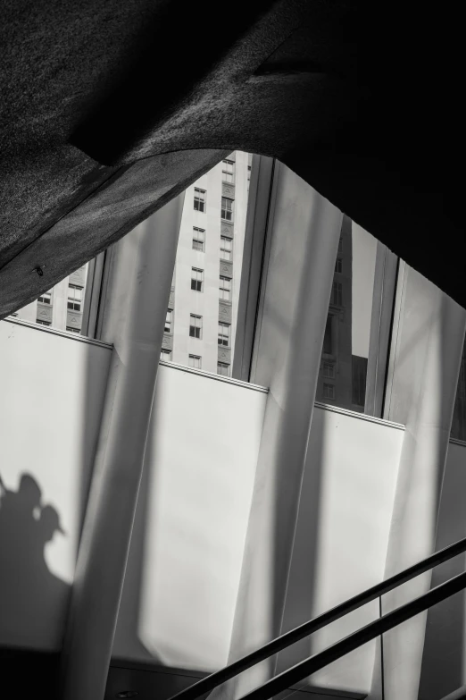 a man riding a skateboard down a flight of stairs, a black and white photo, inspired by Arnold Newman, unsplash contest winner, modernism, folds of fabric, in the middle of new york, tent architecture, people's silhouettes close up