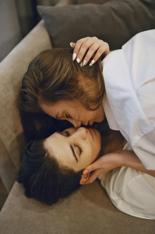 a man and a woman laying on a couch, inspired by Elsa Bleda, trending on pexels, romanticism, lesbian kiss, brunette, close face view, sakimichan