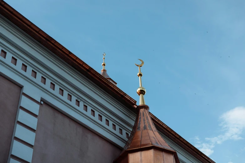 a clock that is on the side of a building, by Julia Pishtar, unsplash contest winner, hurufiyya, minarets, southern slav features, golden curve composition, cloudless sky