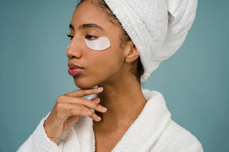 a woman with a towel wrapped around her head, trending on pexels, eye patch over left eye, essence, manuka, beauty campaign