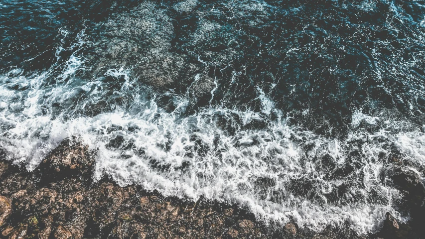 a large body of water next to a rocky shore, an album cover, trending on unsplash, happening, lsd waves, high angle close up shot, background image, multiple stories