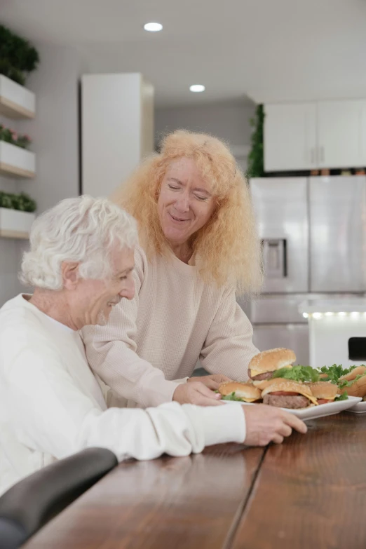 a couple of women sitting at a table with a plate of food, curly white hair, healthcare, overlay, multiple stories