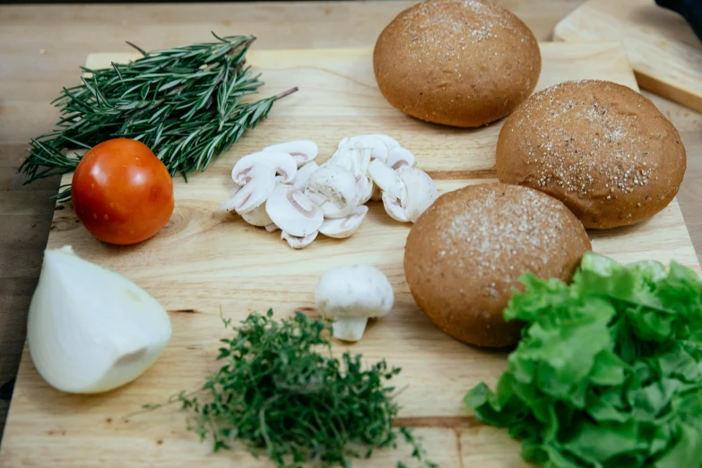 a wooden cutting board topped with buns and vegetables, by Tom Wänerstrand, pexels contest winner, puffballs, herbs, profile image, background image