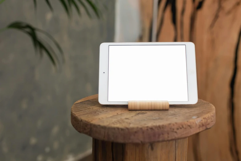 a tablet computer sitting on top of a wooden table, a picture, square, abduzeedo, bamboo, medium - shot