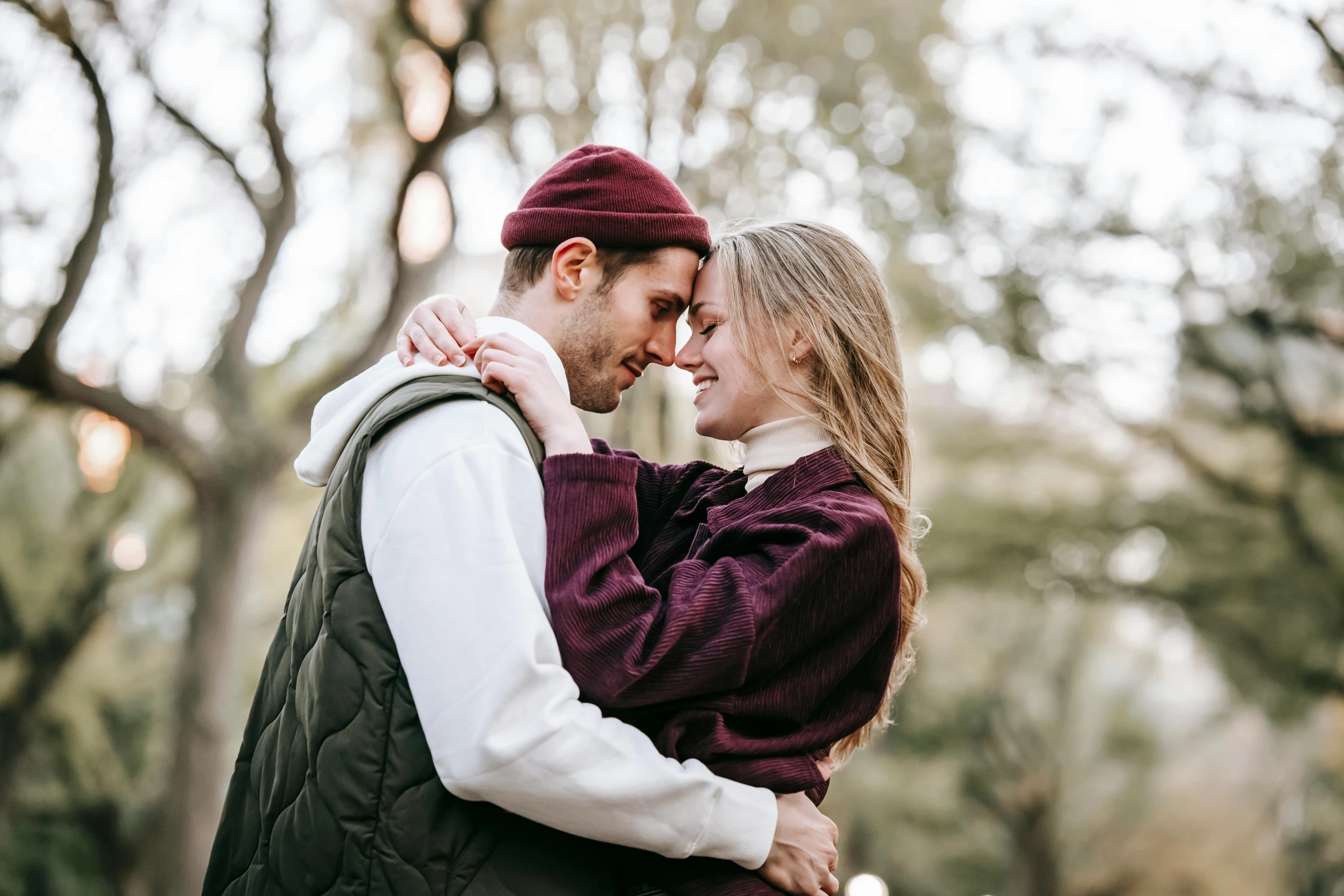 a man and woman embracing each other in a park, trending on pexels, renaissance, wearing a purple breton cap, sydney sweeney, maroon and white, central park