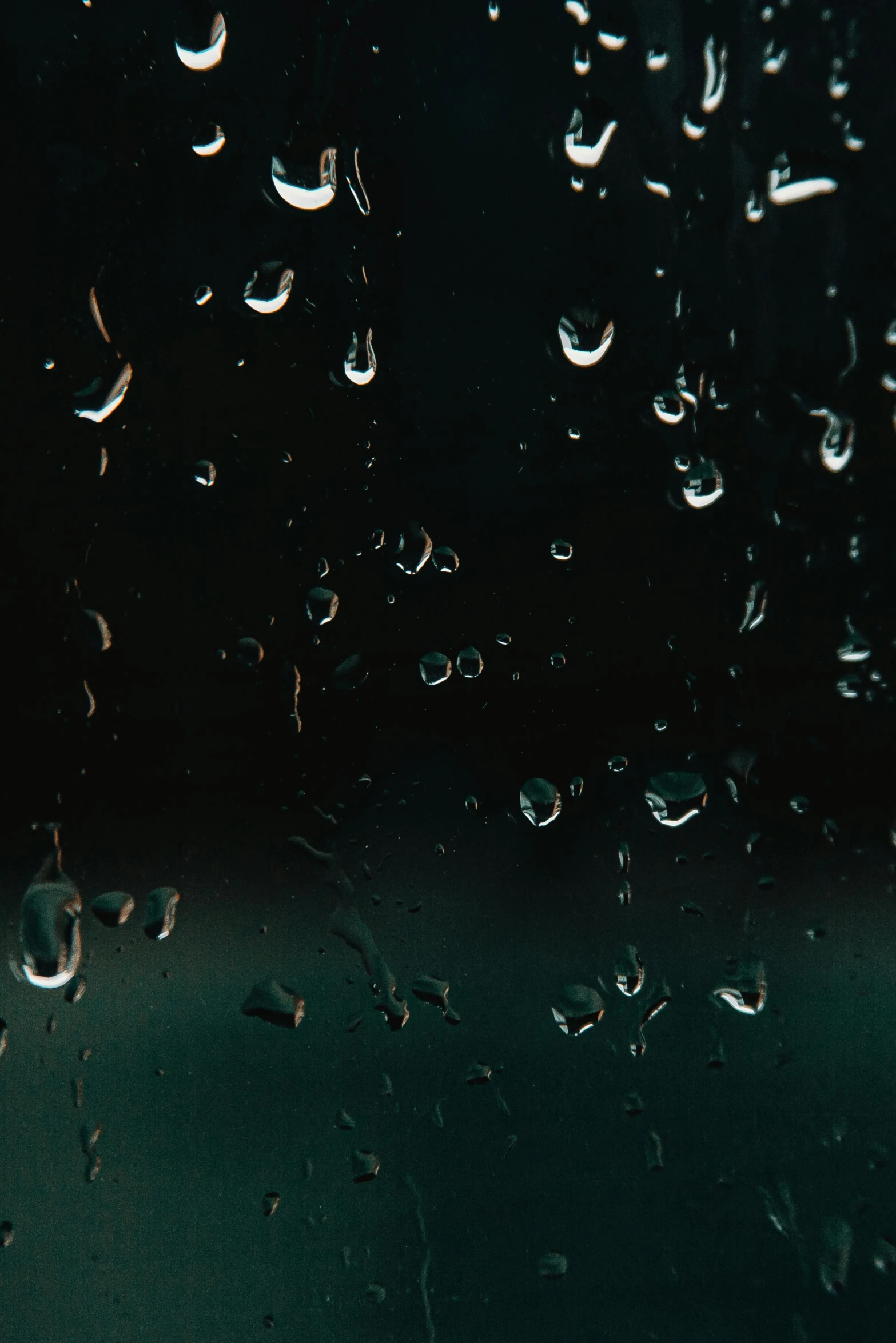 a close up of water droplets on a window, an album cover, inspired by Elsa Bleda, unsplash, conceptual art, in a pitch black room, 4 k hd wallpapear, medium-shot, humid evening