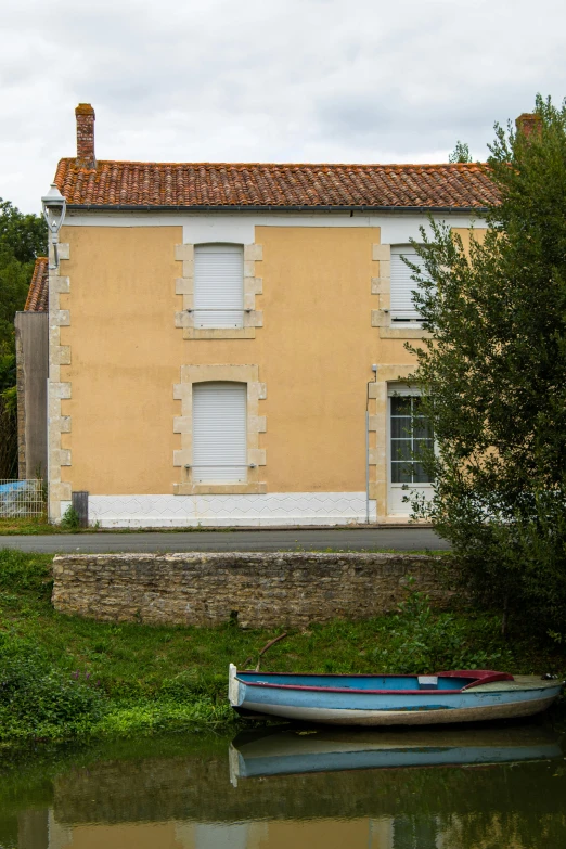 a boat that is sitting in the water, a picture, inspired by Pierre Toutain-Dorbec, in front of a two story house, full frame image, color image, slide show