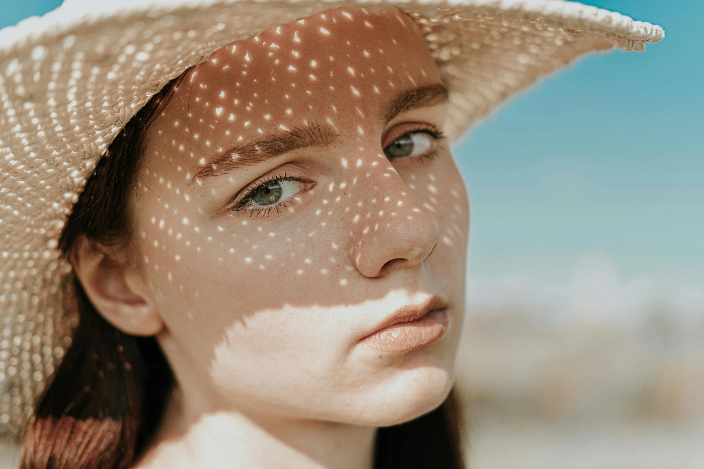 a close up of a person wearing a hat, a stipple, trending on pexels, transparent celestial light gels, more tan face, girl with white eyes, dappled sunlight