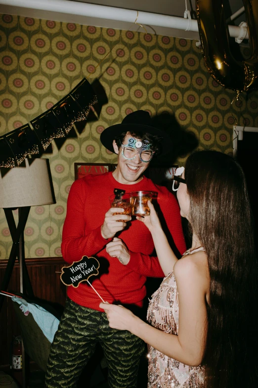 a woman standing next to a man in a room, a polaroid photo, pexels contest winner, happening, halloween celebration, drinking champagne, profile image, cowboy hat and glasses