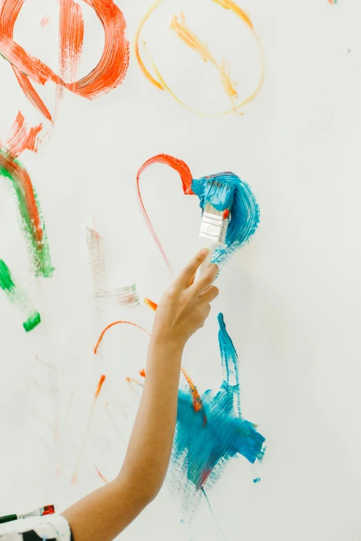 a little boy that is painting on a wall, a child's drawing, inspired by Helen Frankenthaler, pexels, interactive art, hearts, orange and cyan paint decals, on white background, color image