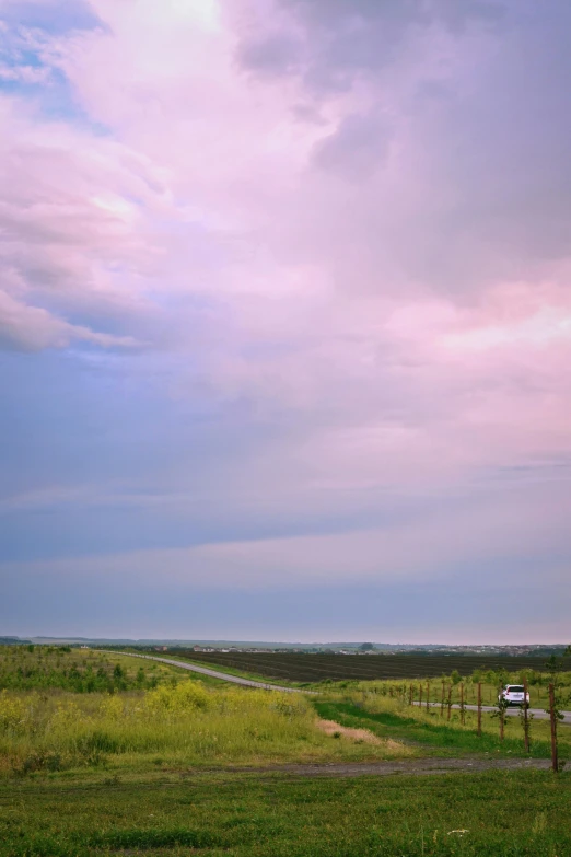 a car is parked on the side of the road, flickr, color field, pink storm clouds, an idyllic vineyard, grasslands, low horizon