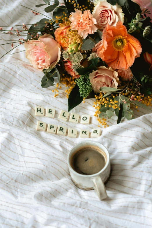 a bouquet of flowers sitting on top of a bed next to a cup of coffee, spring theme, thumbnail, hello, sprong season