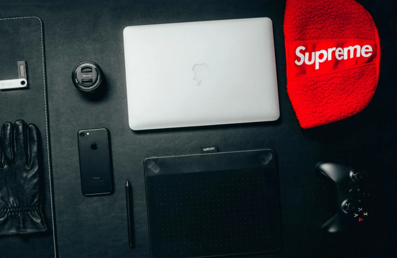 a laptop computer sitting on top of a black table, a still life, trending on pexels, superflat, supreme, streetwear, apple logo, sup