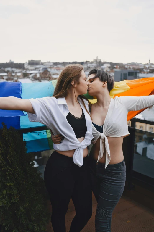 a couple of women standing next to each other, trending on pexels, lesbian embrace, shot from roofline, okuda, posing together in bra
