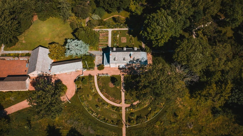 an aerial view of a house surrounded by trees, natural botanical gardens, walking towards the camera, historical setting, skies behind