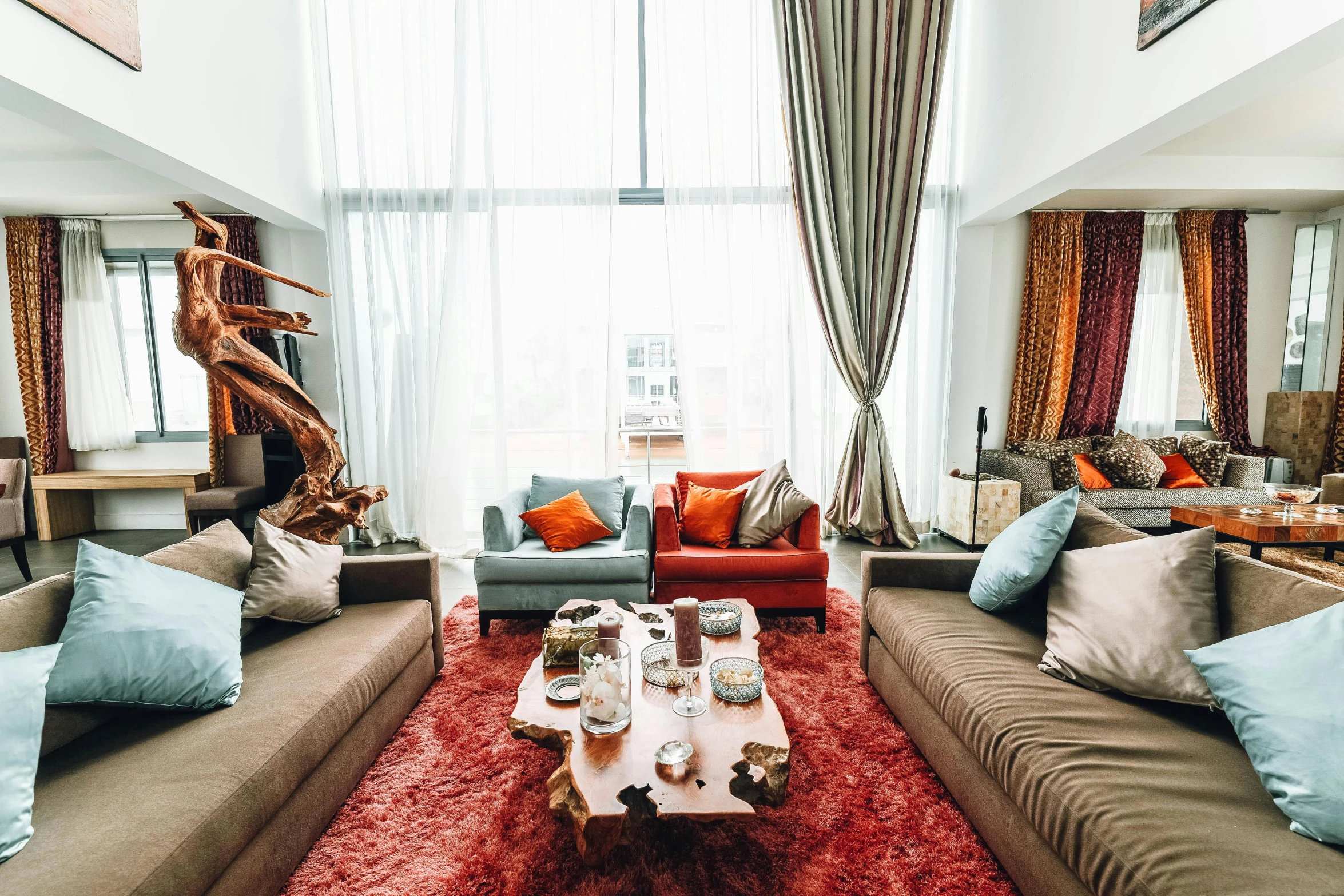 a living room filled with lots of furniture, inspired by Riad Beyrouti, pexels contest winner, red curtains, interior of a loft, luxury condo interior, hippie pad