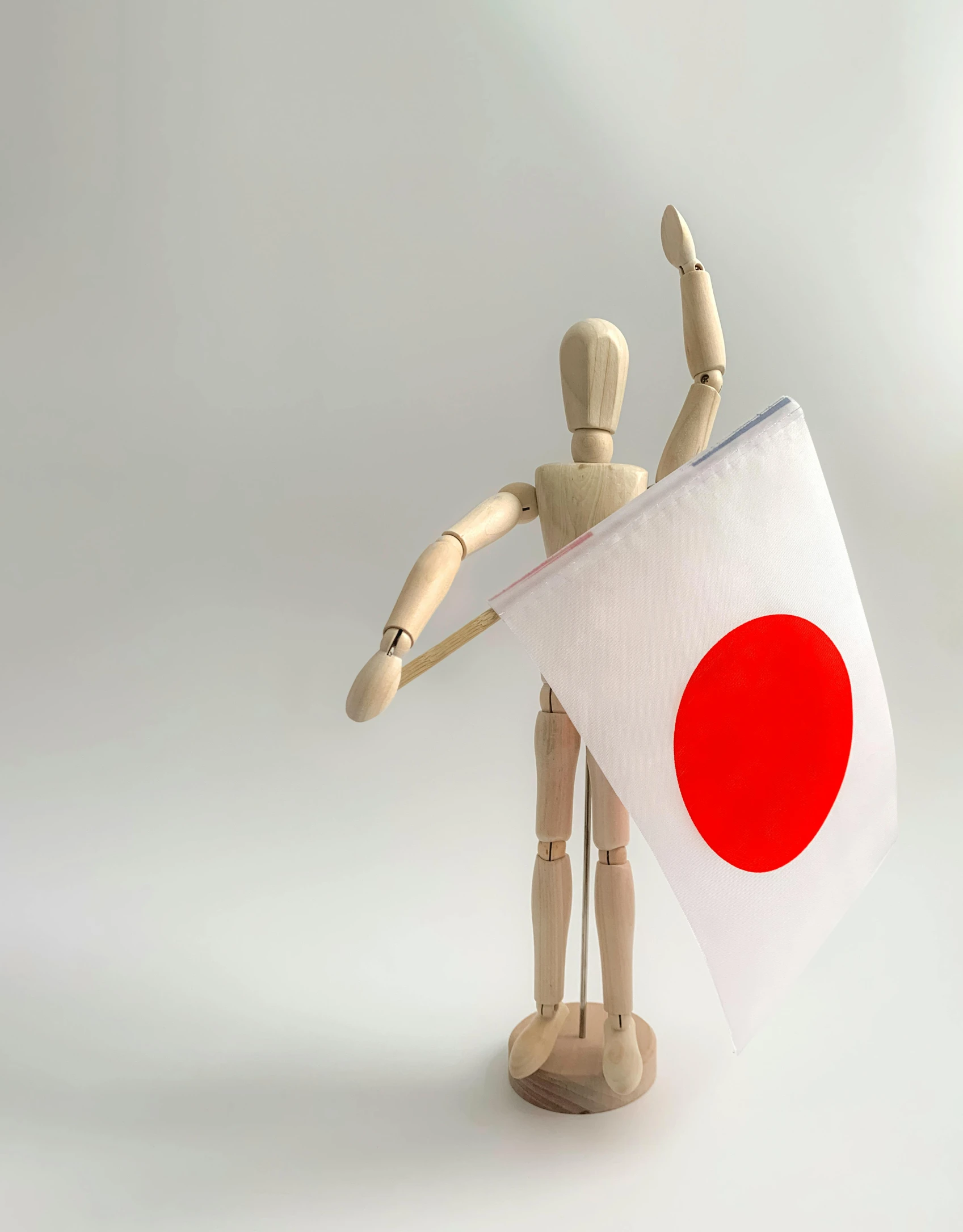 a wooden mannequin holding a japanese flag, unsplash, holding a pudica pose, instagram photo, press shot, flag