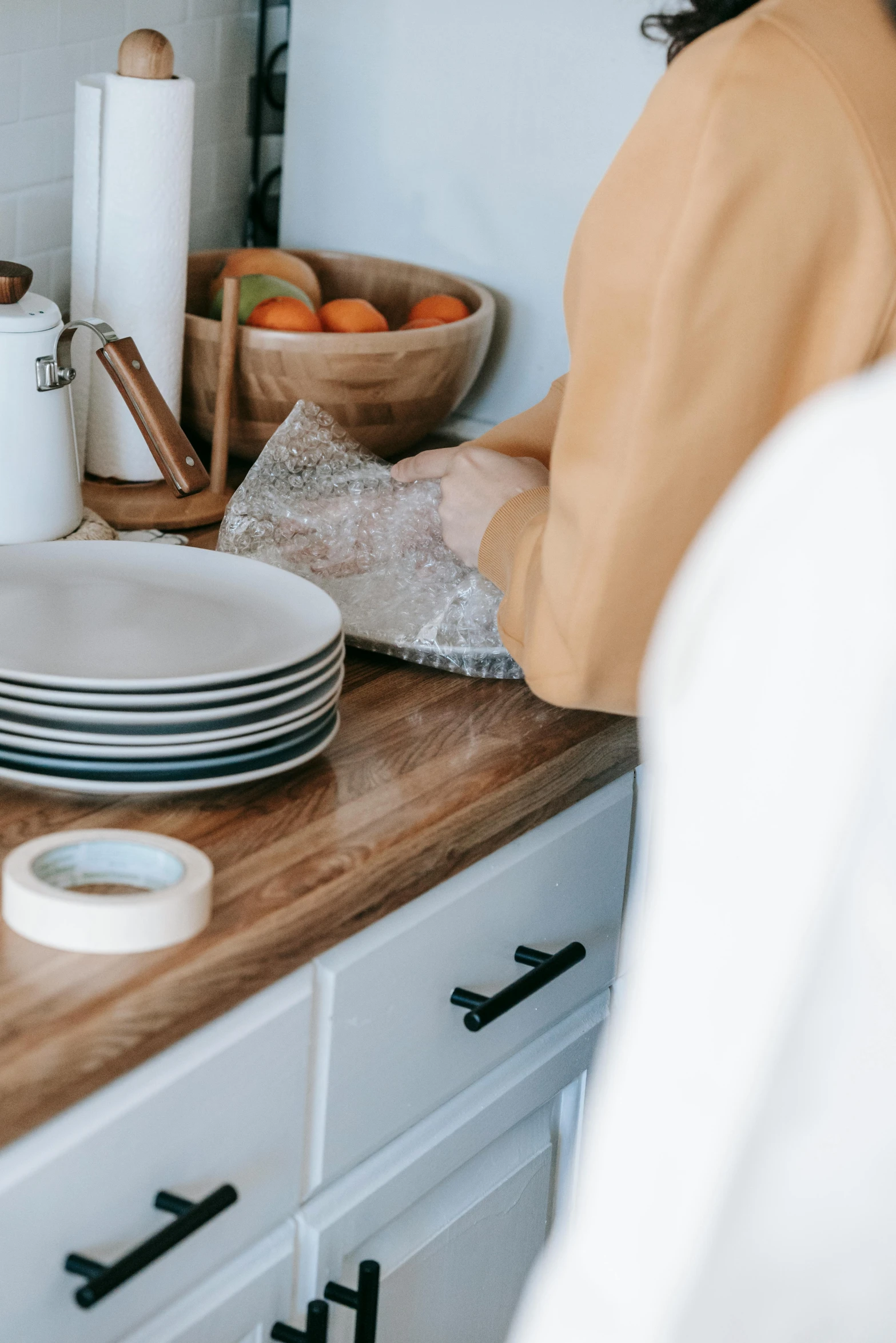 a woman standing in a kitchen preparing food, a still life, by Robbie Trevino, trending on unsplash, plates, natural wood top, plastic wrap, close up details