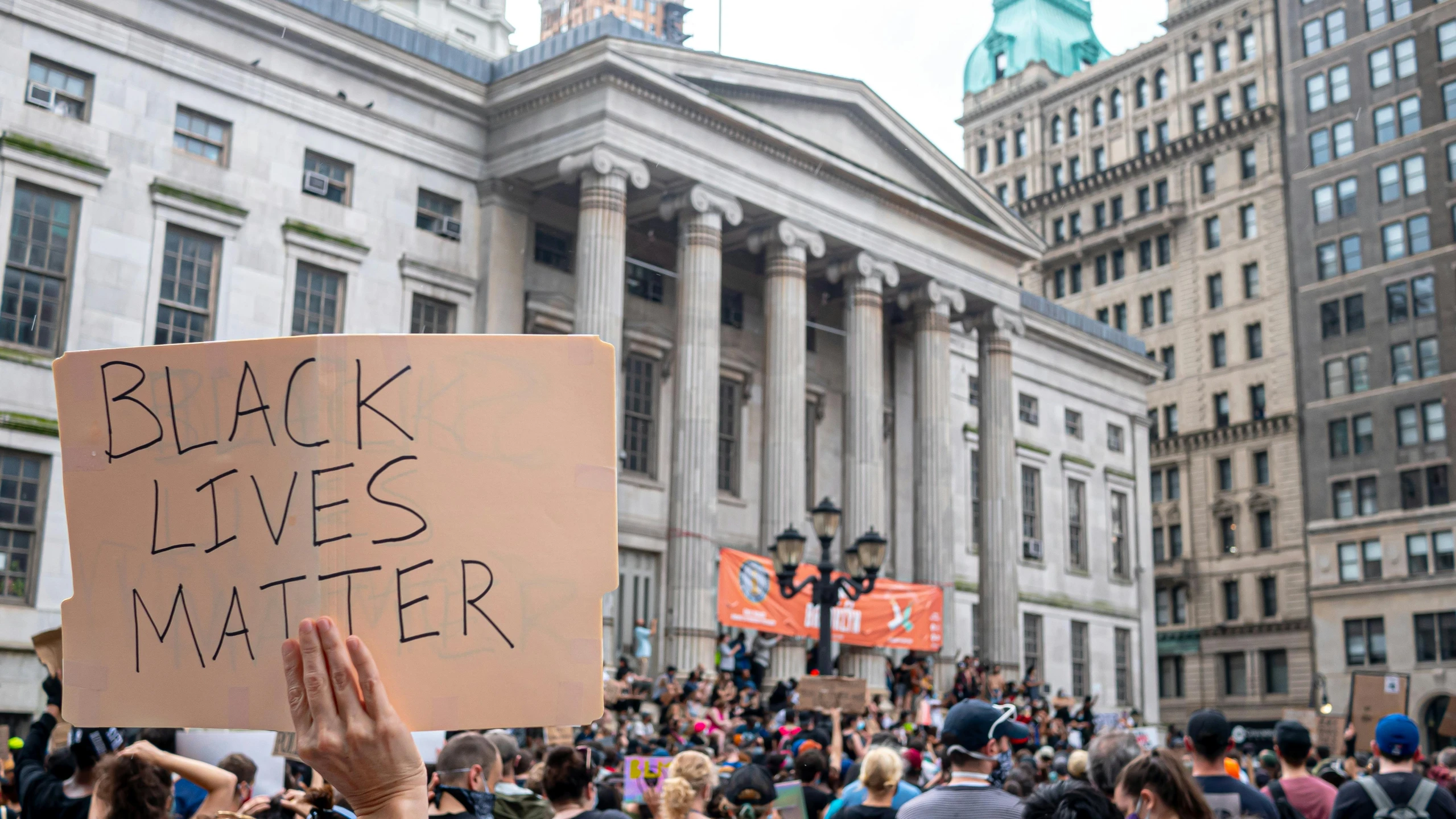 a person holding a sign that says black lives matter, a photo, shutterstock, destroying new york city, 🚿🗝📝