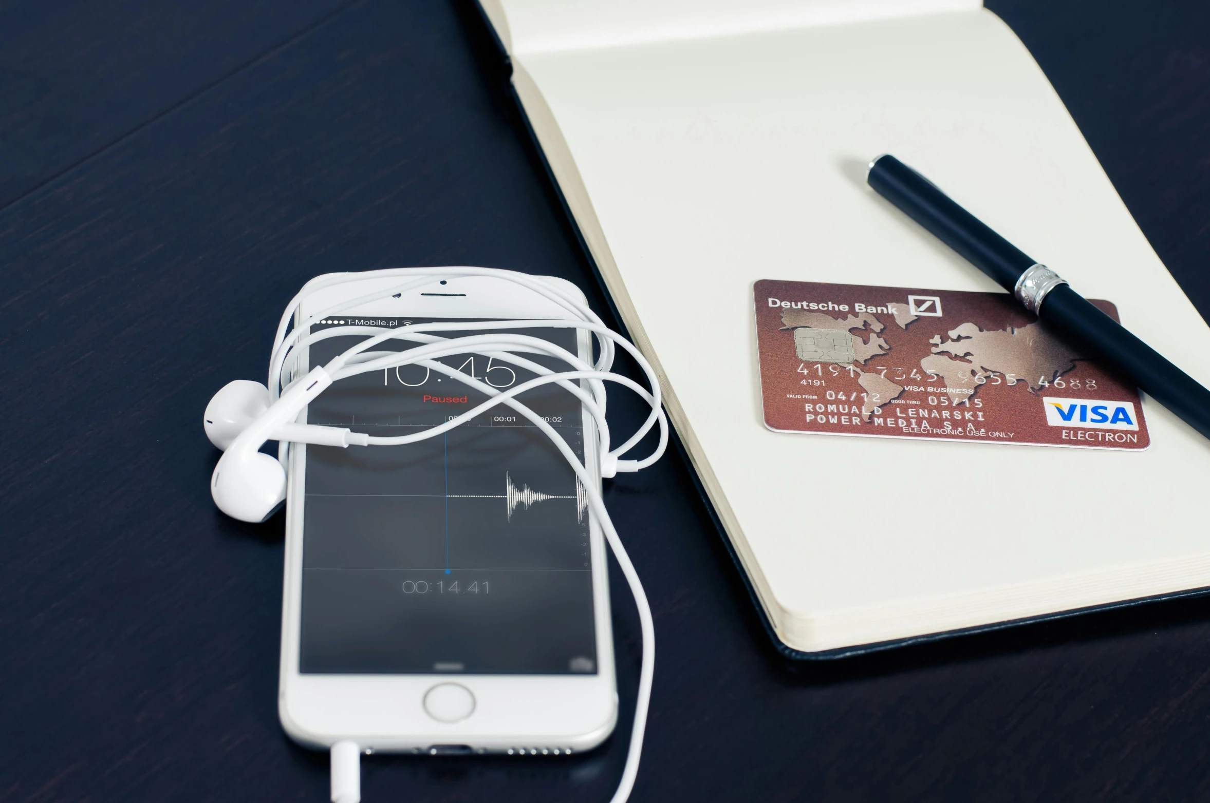 a cell phone sitting next to a notebook and pen, an album cover, unsplash, visa pour l'image, 9 9 designs, electronics, pair of keycards on table