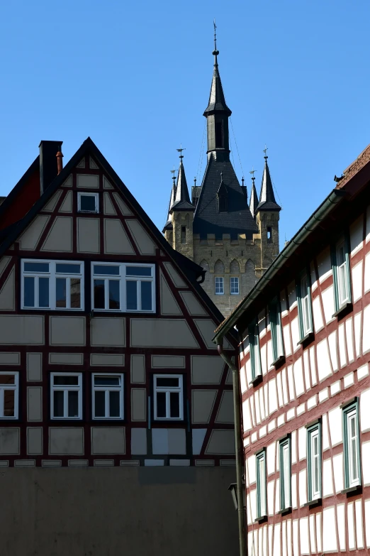 a couple of buildings that are next to each other, by Werner Gutzeit, romanesque, colonial house in background, zoomed in shots, dunwall city, sqare-jawed in medieval clothing