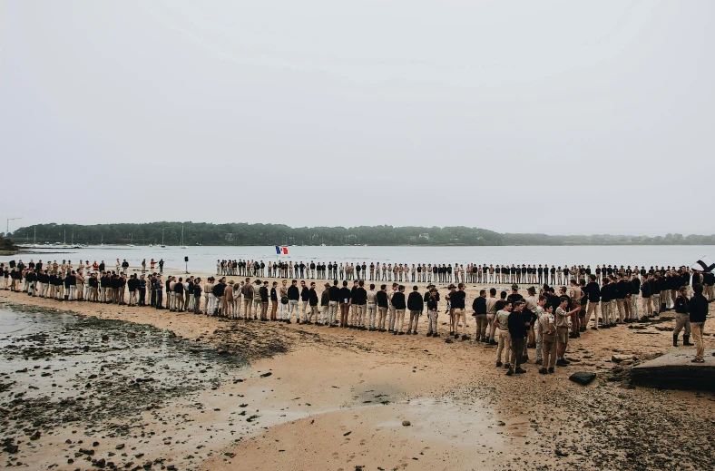 a group of people standing on top of a sandy beach, parade, lachlan bailey, 4k photo”, standing on the water ground