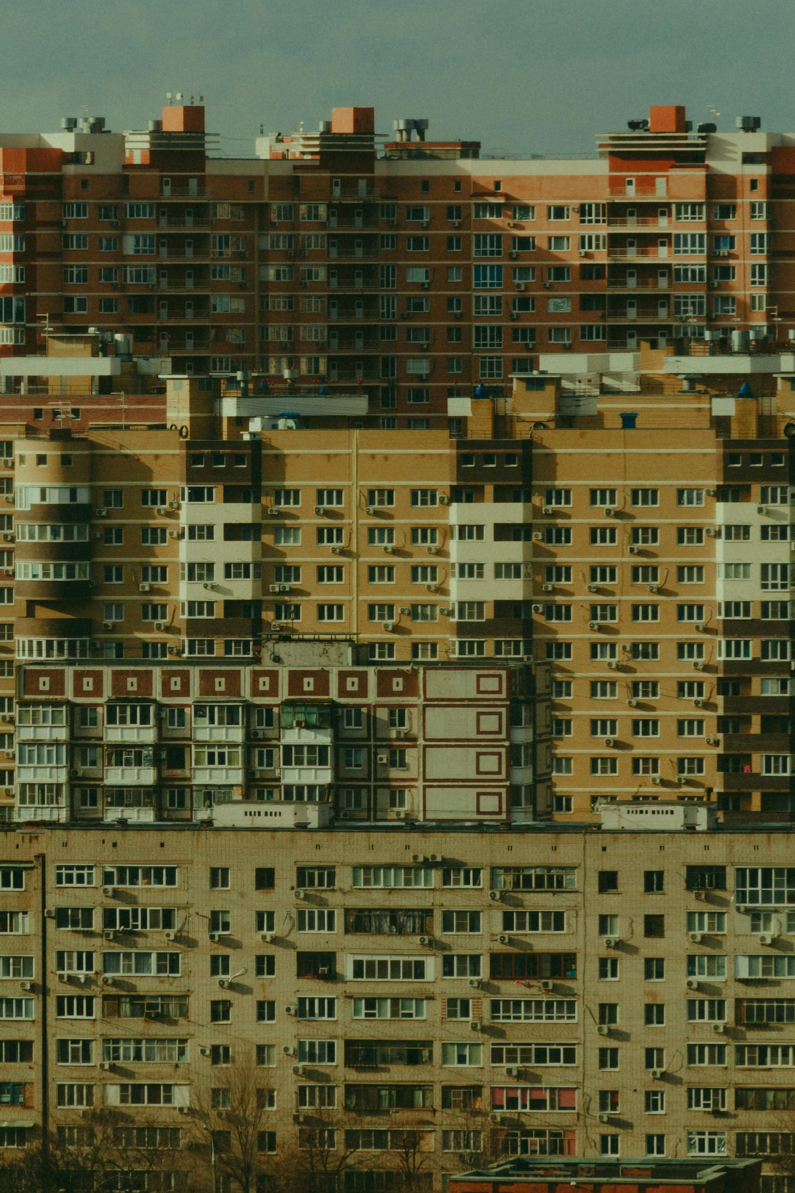 a large city filled with lots of tall buildings, inspired by Elsa Bleda, pexels contest winner, socialist realism, soviet apartment, golden windows, suburb, denis sarazhin