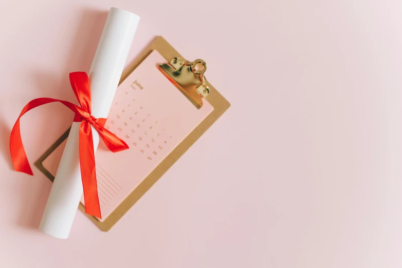 a diploma on a clipboard with a red ribbon, by Emma Andijewska, pexels contest winner, happening, pink pastel, female calendar, thumbnail, festive