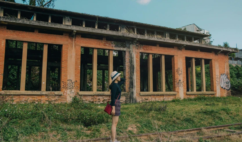 a woman standing in front of an abandoned building, unsplash contest winner, wes anderson style, chinese girl, instagram picture, profile image
