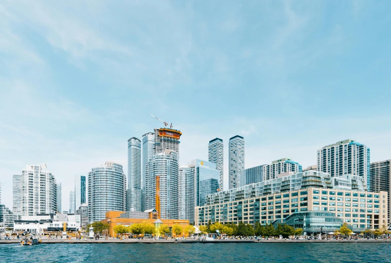 a large body of water surrounded by tall buildings, by Julia Pishtar, pexels contest winner, hyperrealism, canada, shoreline, istock, group photo