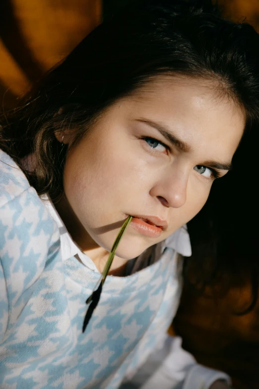 a close up of a person with a flower in their mouth, press shot, with a straw, 1 6 years old, scowl