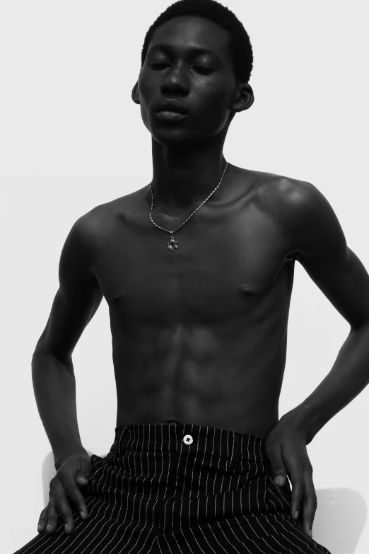 a black and white photo of a man with no shirt, an album cover, trending on pexels, realism, black teenage boy, adut akech, black jewerly, young boy